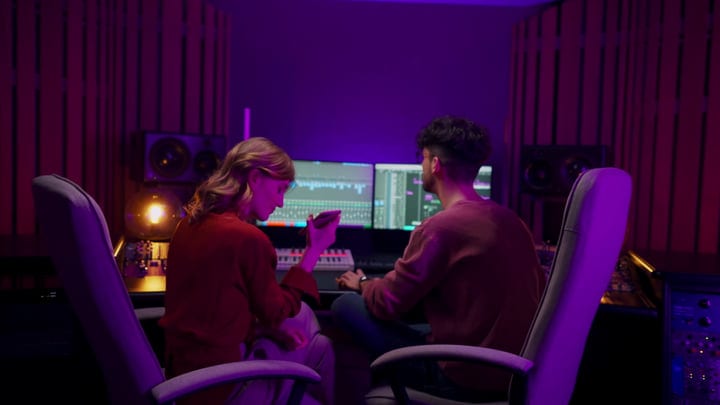 Creative Minds Collaborate In A Dimly Lit Studio Session