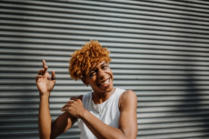 Joyful Runner Smiling Against Urban Metal Shutters