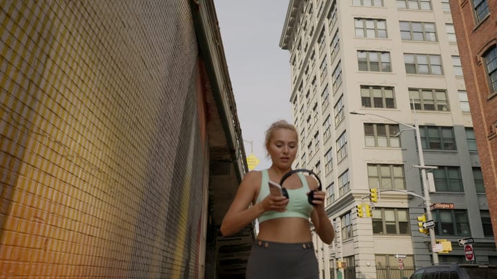 Young Runner Adjusts Headphones On Busy NYC Street