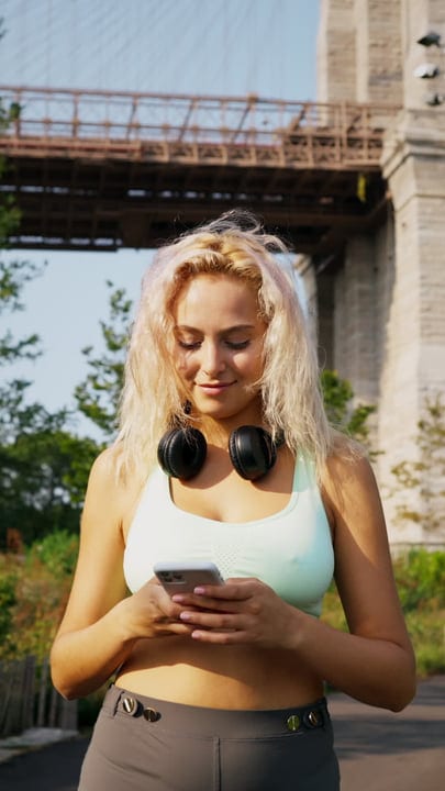 Urban Runner Checks Phone Under Iconic Bridge