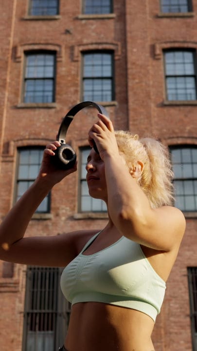 Morning Runner Adjusts Headphones In Urban Setting