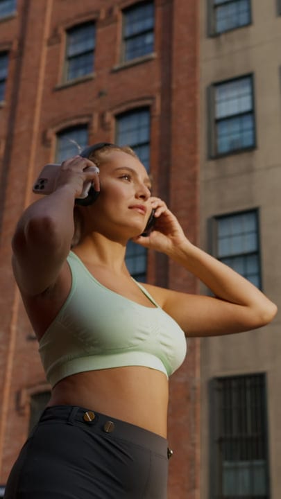 Urban Runner Adjusts Headphones On Busy NYC Street
