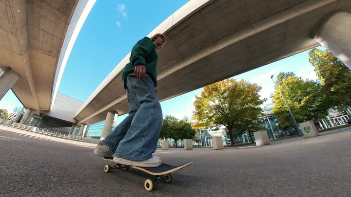 Skater Glides Under City Overpass in Autumn Light