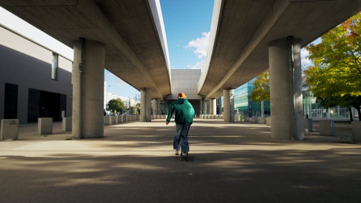 Person Skateboarding Under Concrete Overpass On A Sunny Autumn Day