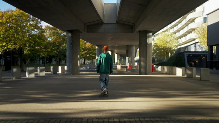 Skateboarder Glides Through Urban Underpass on a Sunny Day