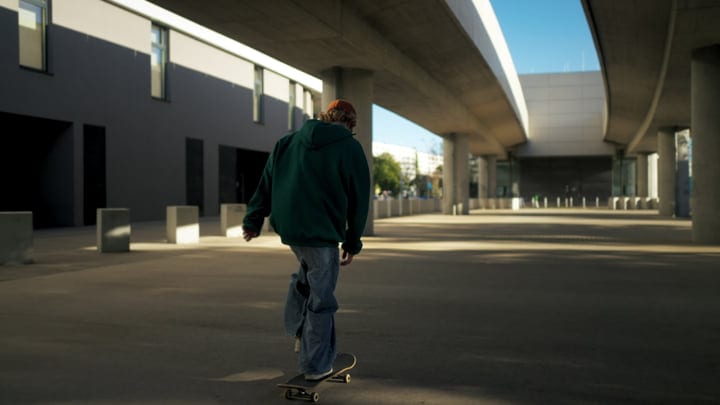 Urban Skater Glides Through Modern Architecture Shadows