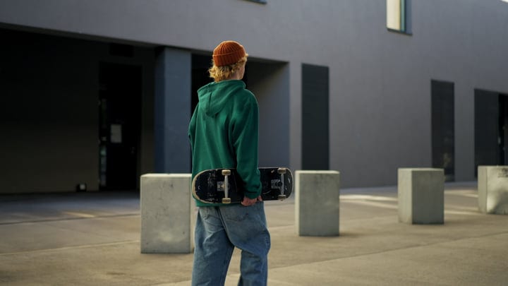 Urban Youth Holds Skateboard In Modern Cityscape