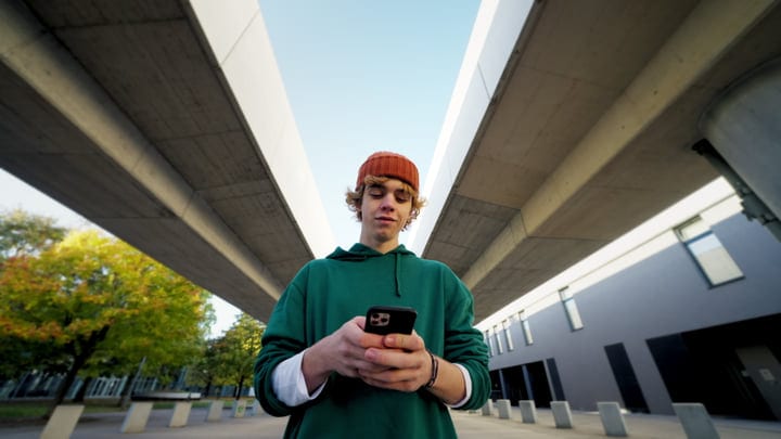 Young Urban Dancer Texts Under Modern Bridge