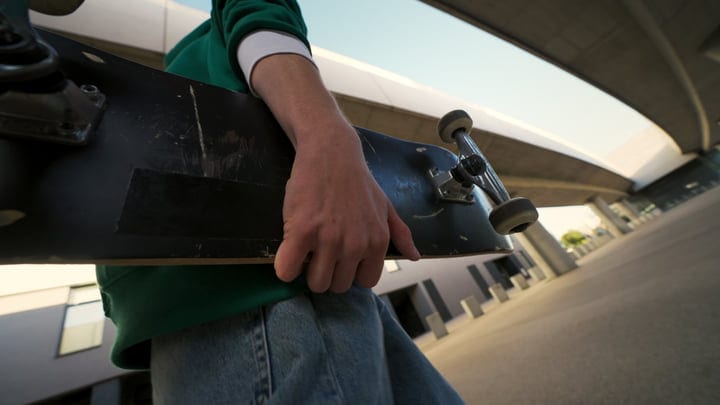 Urban Skater Grips His Board Under City Lights