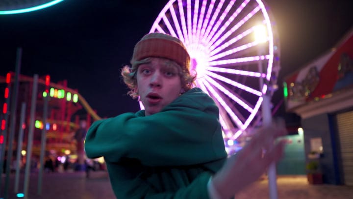 Youthful Energy Explodes Against Neon Carnival Backdrop
