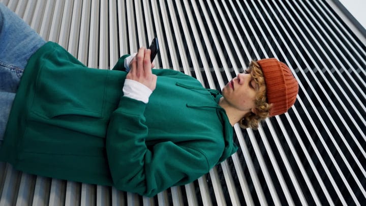 Young Urban Dancer Relaxing Against A Geometric Backdrop