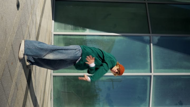 Energetic Street Dancer Moves Against Urban Backdrop