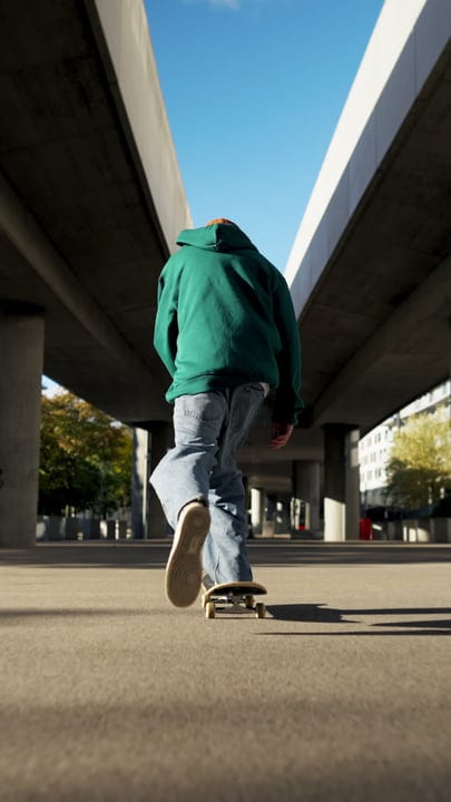 Urban Skater Glides Effortlessly Under Bright Blue Sky