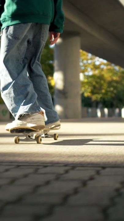Urban Skater Gliding Through Sunlit City Streets