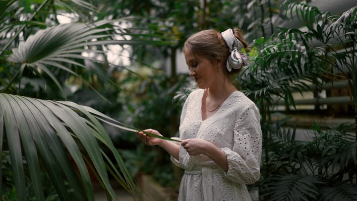 Woman Relishing Tranquility In A Lush Tropical Garden