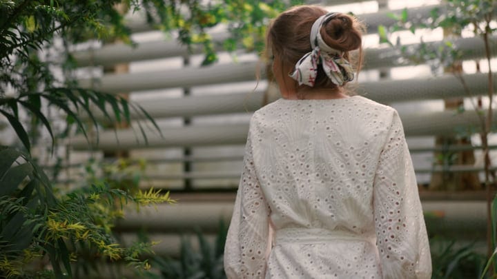 A Woman Stands Peacefully in a Lush Tropical Garden