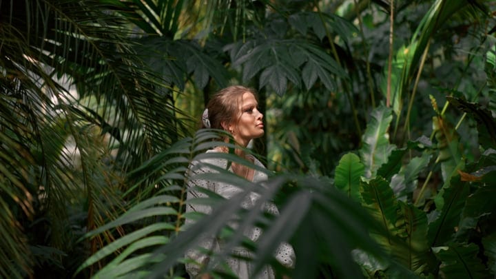 A Woman Embraces Nature In A Lush Tropical Garden
