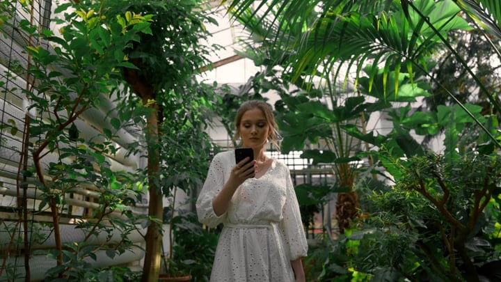 A Woman Connects with Nature in Lush Greenhouse