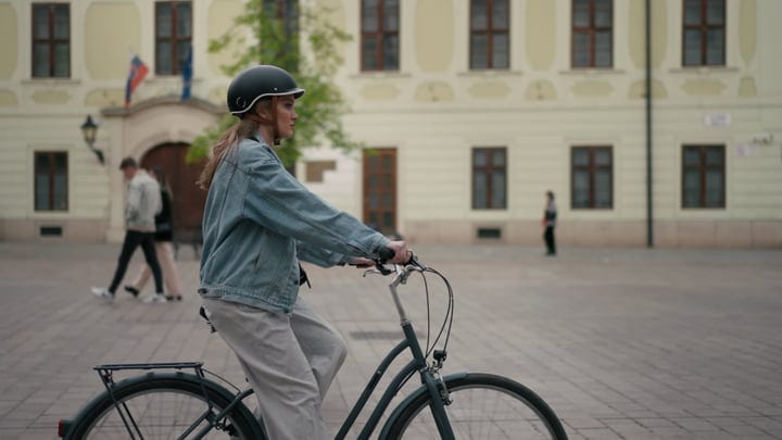 Young Woman Cycling Through Historic European Square