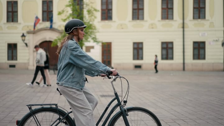 A Woman Pedals Through a Historic European Square