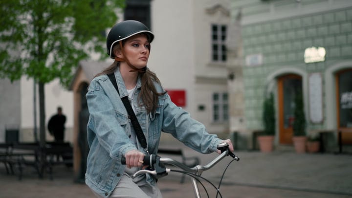 Young Woman Navigates City Streets on Bicycle