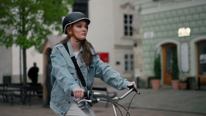 Young Woman Cycling Through Quaint European Streets