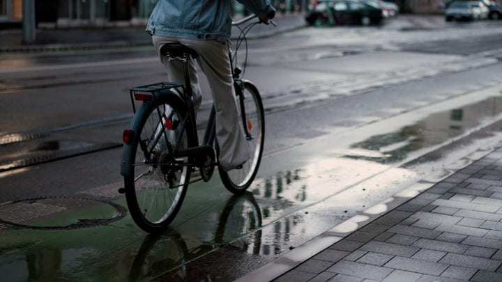 Cyclist Navigates Rain-Soaked Streets On Wet Morning