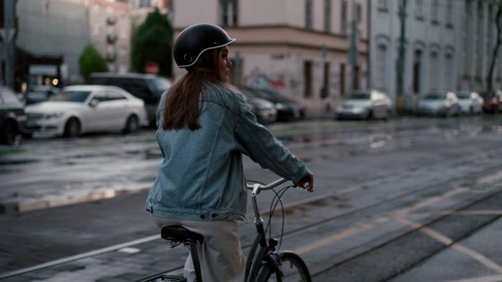 Young Woman Pedals Through a Rain-Kissed European City