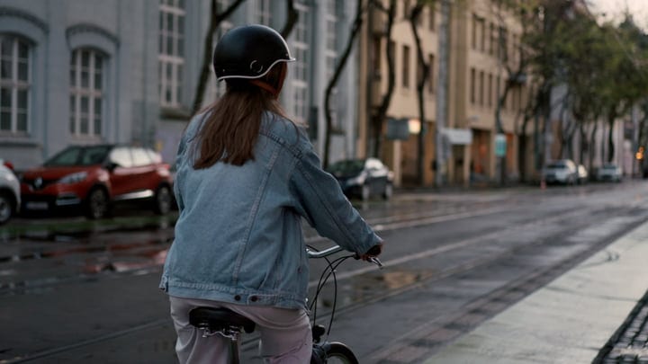 Urban Cyclist Navigates Wet Streets At Dusk