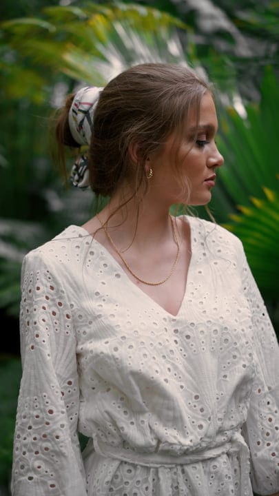 Elegant Woman in Lace Dress Among Lush Tropics