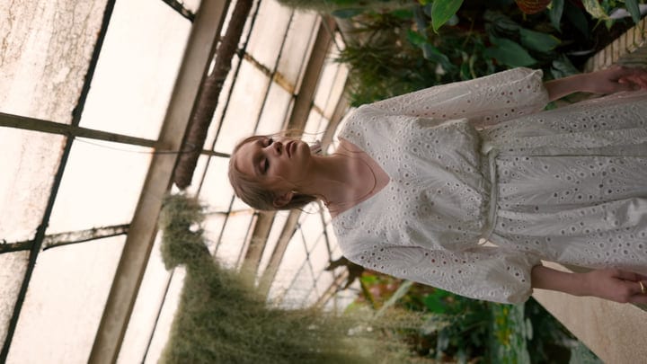 Serene Woman in a Sunlit Tropical Greenhouse Setting