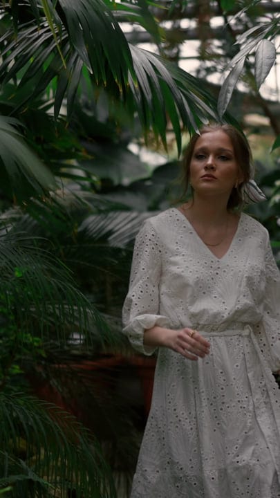 Serene Woman Strolls Through Lush Tropical Oasis