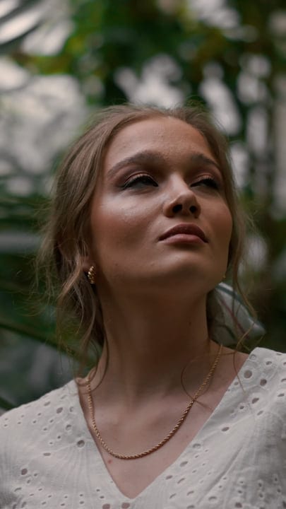 Woman Embraces Serenity In Lush Tropical Garden