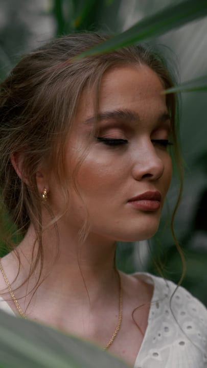 Serene Woman Immersed In Lush Tropical Foliage