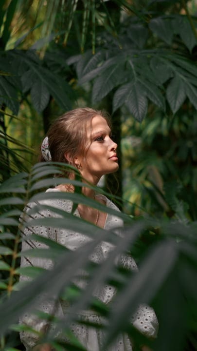 Woman Contemplates Amidst Lush Tropical Foliage