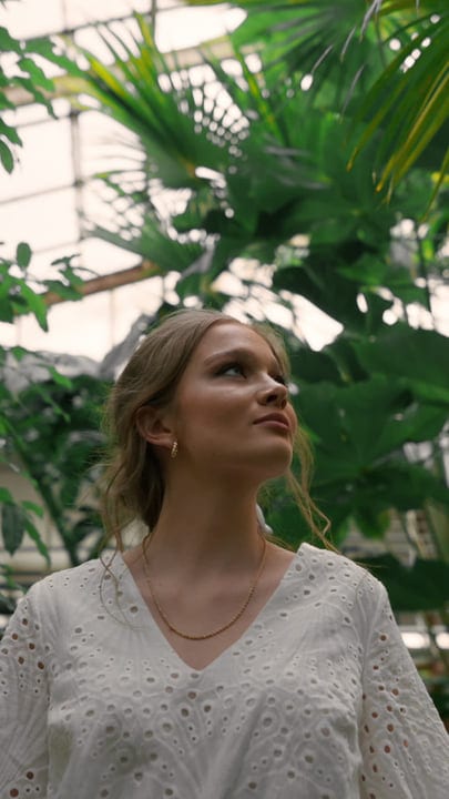 A Woman Embraces Serenity In A Lush Tropical Garden