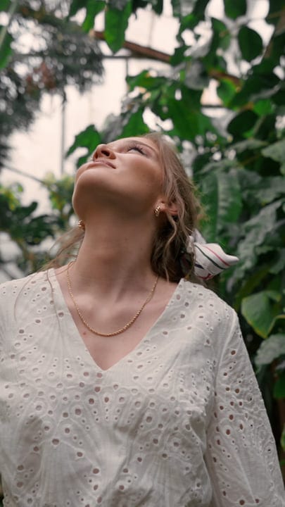 Woman Embraces Serenity In Lush Tropical Garden