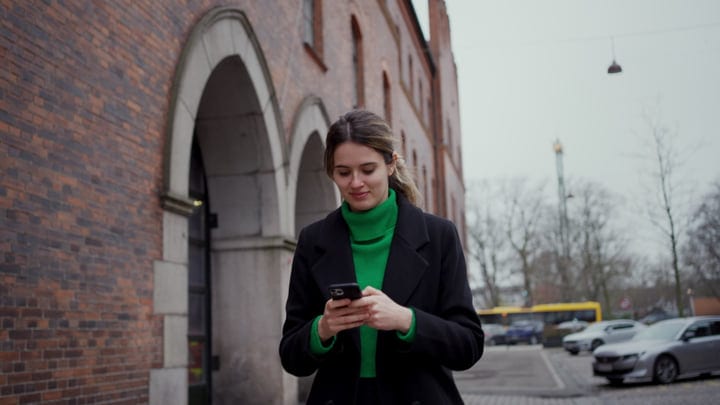 Businesswoman Engages with Her Phone on Copenhagen Street