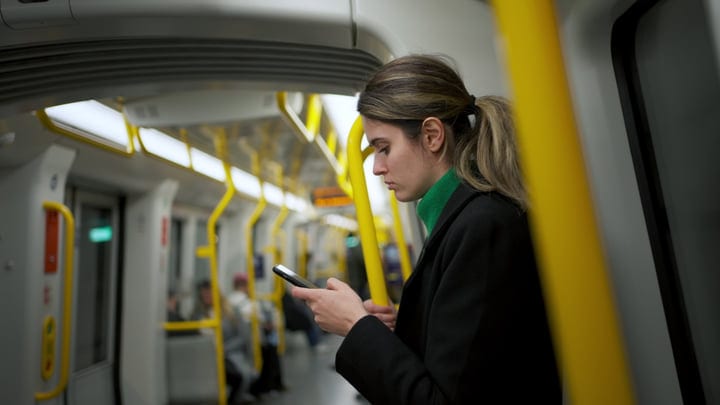 Woman Checks Smartphone On Modern Subway Train During Her Commute