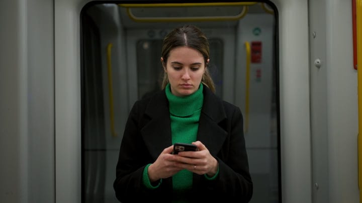 Woman Using Smartphone On European Public Transport Commute