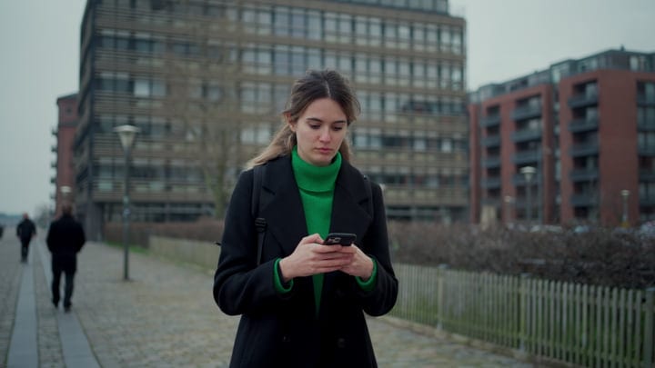 Focused Businesswoman Checks Her Phone In Copenhagen Street