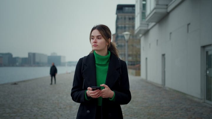 Contemplative Businesswoman Strolls Along Copenhagen Waterfront