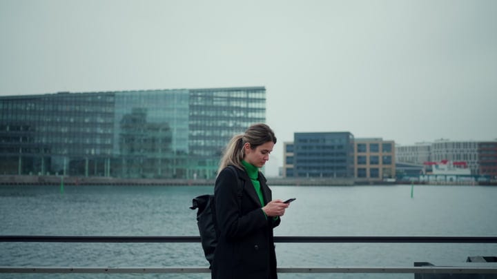 Focused Businesswoman Walks Along Copenhagen Waterfront