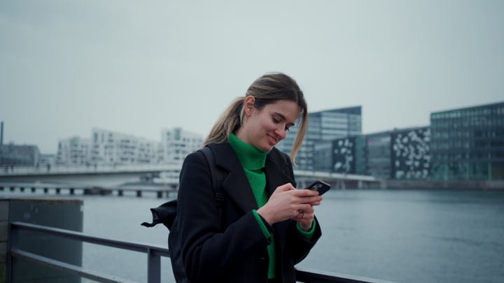 Businesswoman Checks Smartphone By Copenhagen Waterfront