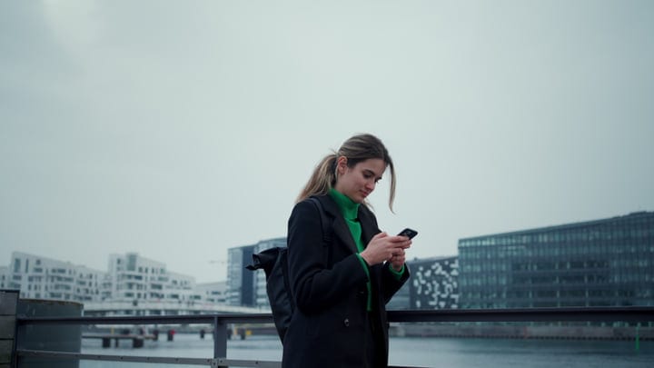 Businesswoman Checks Phone By The Copenhagen Waterfront