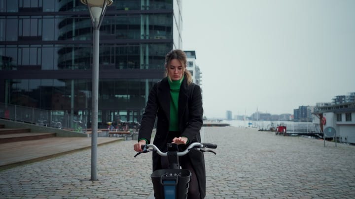 Focused Businesswoman Navigates Copenhagen's Cobblestone Streets