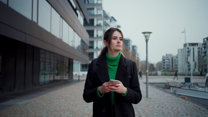 Contemplative Businesswoman in Vibrant Green Sweater Outdoors