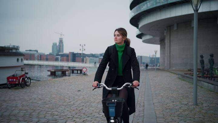Confident Businesswoman Cycling Through Copenhagen Streets