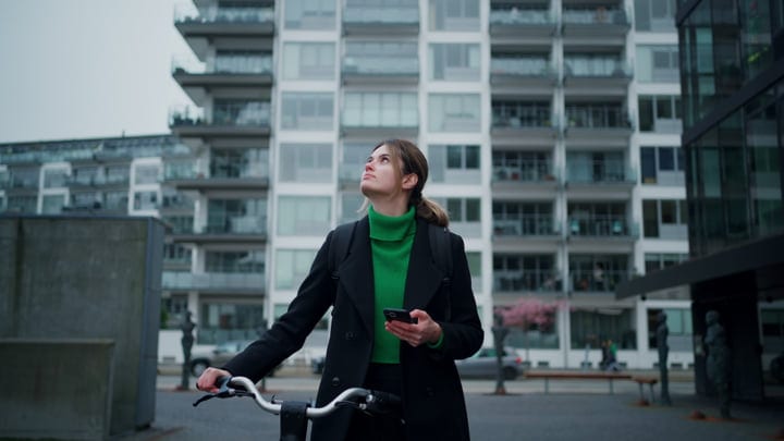 Businesswoman Pauses With Bicycle In Urban Copenhagen
