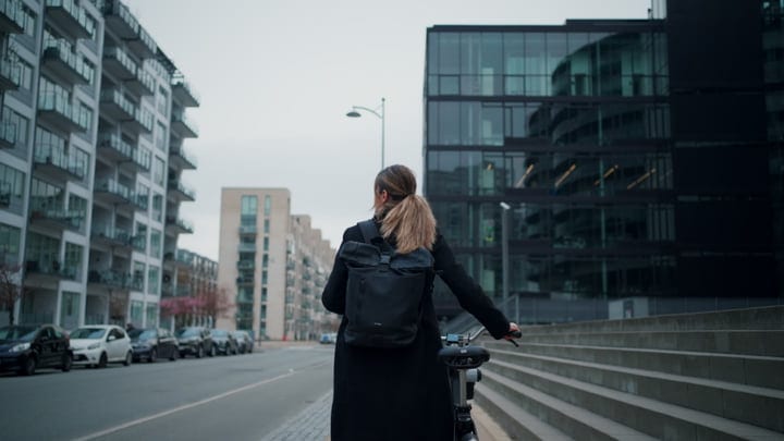 A Businesswoman Navigates Modern Copenhagen Streets By Bike
